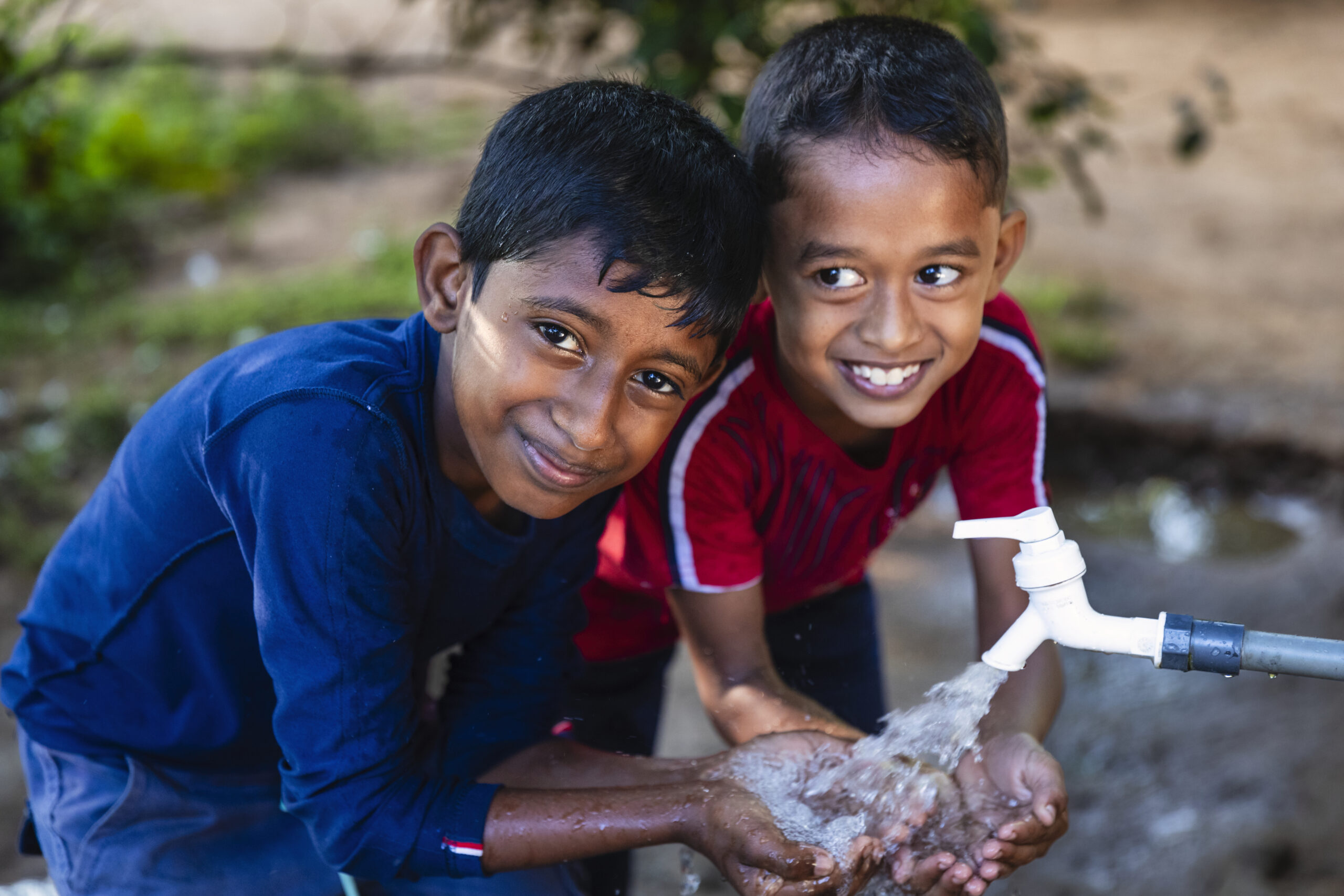 Sri Lankan young boys drinking fresh water, Sigiriya, Ceylon.