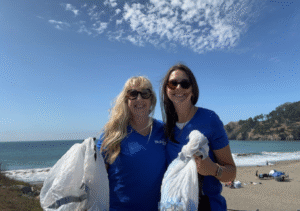 Two BluPeak Foundation Members cleaning up the beach