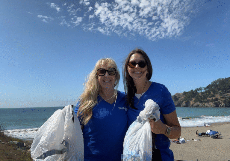 Two BluPeak Foundation Members cleaning up the beach